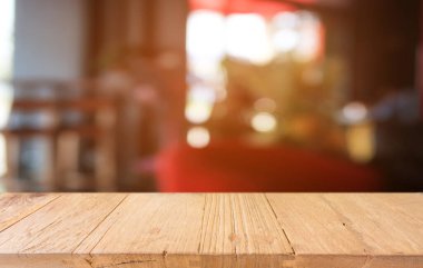 Restoranın soyut bulanık arka planının önündeki boş, siyah ahşap masa. Ürünlerinizi görüntülemek ya da montajlamak için kullanılabilir.
