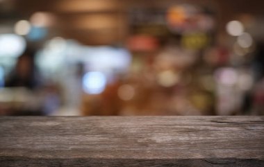 Restoranın soyut bulanık arka planının önündeki boş, siyah ahşap masa. Ürünlerinizi görüntülemek ya da montajlamak için kullanılabilir. 