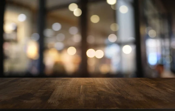 Restoranın soyut bulanık arka planının önündeki boş, siyah ahşap masa. Ürünlerinizi görüntülemek ya da montajlamak için kullanılabilir.