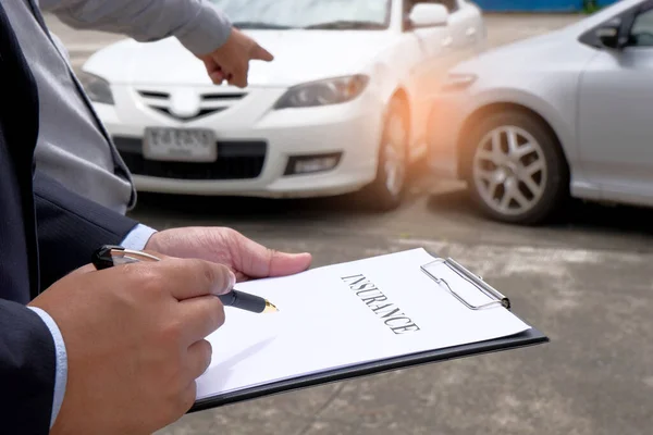 Loss Adjuster Insurance Agent Inspecting Damaged Car