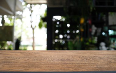 Restoranın soyut bulanık arka planının önündeki boş, siyah ahşap masa. Ürünlerinizi görüntülemek ya da montajlamak için kullanılabilir.