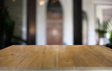 Restoranın soyut bulanık arka planının önündeki boş, siyah ahşap masa. Ürünlerinizi görüntülemek ya da montajlamak için kullanılabilir.