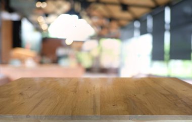 Restoranın soyut bulanık arka planının önündeki boş, siyah ahşap masa. Ürünlerinizi görüntülemek ya da montajlamak için kullanılabilir.