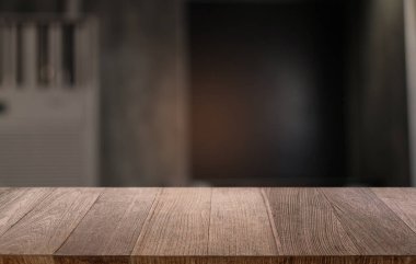 Restoranın soyut bulanık arka planının önündeki boş, siyah ahşap masa. Ürünlerinizi görüntülemek ya da montajlamak için kullanılabilir.