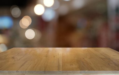 Restoranın soyut bulanık arka planının önündeki boş, siyah ahşap masa. Ürünlerinizi görüntülemek ya da montajlamak için kullanılabilir. 