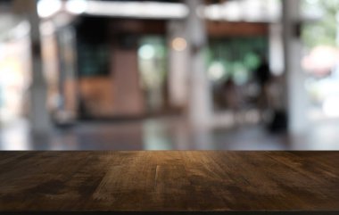 Restoranın soyut bulanık arka planının önündeki boş, siyah ahşap masa. Ürünlerinizi görüntülemek ya da montajlamak için kullanılabilir.