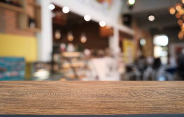 Restoranın soyut bulanık arka planının önündeki boş, siyah ahşap masa. Ürünlerinizi görüntülemek ya da montajlamak için kullanılabilir. 