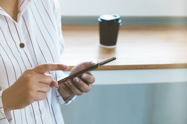 Reklam mesajınız ya da tanıtım içeriğiniz için cep telefonunuzu boş fotokopi sahnesiyle kapatın. Kahve molasında cep telefonundan izleyen kız.