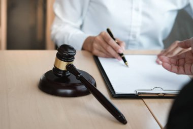 Hukuk danışmanı müvekkiline tokmak ve hukuk hukuku ile imzalanmış bir sözleşme sunar. Adalet ve avukat kavramı