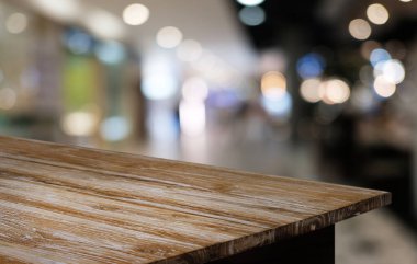 Restoranın soyut bulanık arka planının önündeki boş, siyah ahşap masa. Ürünlerinizi görüntülemek ya da montajlamak için kullanılabilir. 