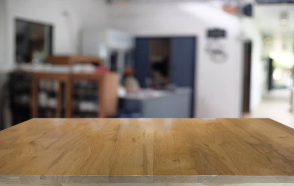 Restoranın soyut bulanık arka planının önündeki boş, siyah ahşap masa. Ürünlerinizi görüntülemek ya da montajlamak için kullanılabilir.