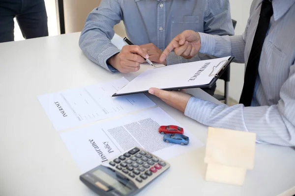 Sales manager giving advice application form document, considering mortgage loan offer for car and house insurance