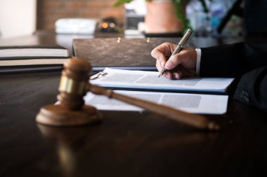 Hukuk danışmanı müvekkiline tokmak ve hukuk hukuku ile imzalanmış bir sözleşme sunar. Adalet ve avukat kavramı