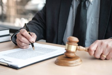 Hukuk danışmanı müvekkiline tokmak ve hukuk hukuku ile imzalanmış bir sözleşme sunar. Adalet ve avukat kavramı