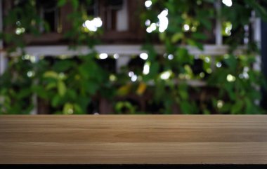 Restoranın soyut bulanık arka planının önündeki boş, siyah ahşap masa. Ürünlerinizi görüntülemek ya da montajlamak için kullanılabilir.