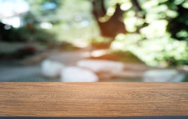 Restoranın soyut bulanık arka planının önündeki boş, siyah ahşap masa. Ürünlerinizi görüntülemek ya da montajlamak için kullanılabilir. 