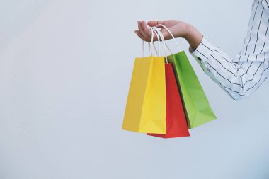 Asyalı kızlar ellerinde alışveriş torbaları tutuyor. Alışveriş merkezinde tüketim yaşam tarzı kavramı