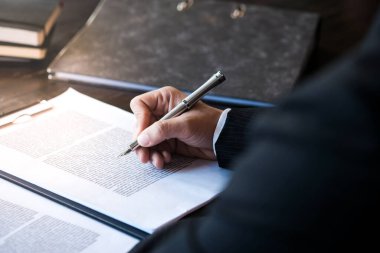 Hukuk danışmanı müvekkiline tokmak ve hukuk hukuku ile imzalanmış bir sözleşme sunar. Adalet ve avukat kavramı
