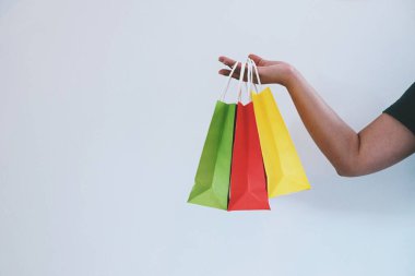 Asyalı kızlar ellerinde alışveriş torbaları tutuyor. Alışveriş merkezinde tüketim yaşam tarzı kavramı