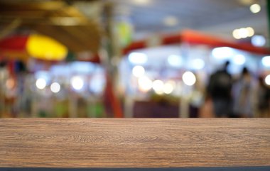 Restoranın soyut bulanık arka planının önündeki boş, siyah ahşap masa. Ürünlerinizi görüntülemek ya da montajlamak için kullanılabilir.