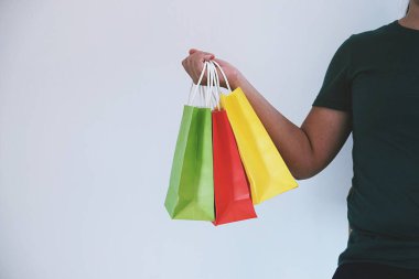 Asyalı kızlar ellerinde alışveriş torbaları tutuyor. Alışveriş merkezinde tüketim yaşam tarzı kavramı