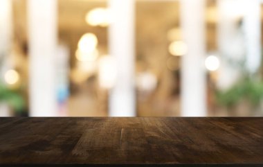 Restoranın soyut bulanık arka planının önündeki boş, siyah ahşap masa. Ürünlerinizi görüntülemek ya da montajlamak için kullanılabilir. 