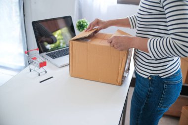 Kadın evde paket teslimat kutusu hazırlıyor online sipariş alışverişi