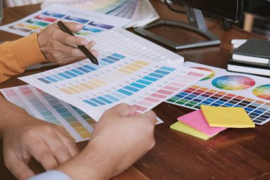 Grafik tasarımcısı dijital tablet üzerinde çalışıyor. Grafik tablet ve renk örneklerine resim çizen sanatçı