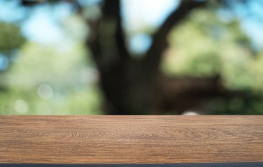 Restoranın soyut bulanık arka planının önündeki boş, siyah ahşap masa. Ürünlerinizi görüntülemek ya da montajlamak için kullanılabilir. 