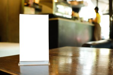 Bar restoranının kafesinde ahşap masada duran metin pazarlama promosyonu için menü çerçeve alanı