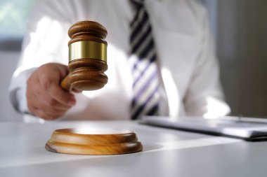 Hukuk danışmanı müvekkiline tokmak ve hukuk hukuku ile imzalanmış bir sözleşme sunar. Adalet ve avukat kavramı