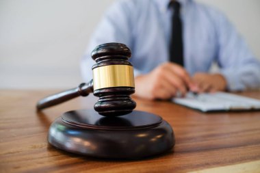 Hukuk danışmanı müvekkiline tokmak ve hukuk hukuku ile imzalanmış bir sözleşme sunar. Adalet ve avukat kavramı