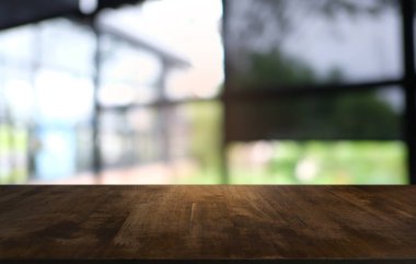 Restoranın soyut bulanık arka planının önündeki boş, siyah ahşap masa. Ürünlerinizi görüntülemek ya da montajlamak için kullanılabilir.