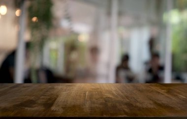 Restoranın soyut bulanık arka planının önündeki boş, siyah ahşap masa. Ürünlerinizi görüntülemek ya da montajlamak için kullanılabilir.