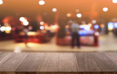 Restoranın soyut bulanık arka planının önündeki boş, siyah ahşap masa. Ürünlerinizi görüntülemek ya da montajlamak için kullanılabilir. 