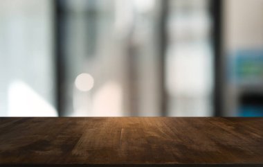 Restoranın soyut bulanık arka planının önündeki boş, siyah ahşap masa. Ürünlerinizi görüntülemek ya da montajlamak için kullanılabilir. 