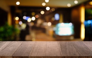 Restoranın soyut bulanık arka planının önündeki boş, siyah ahşap masa. Ürünlerinizi görüntülemek ya da montajlamak için kullanılabilir. 
