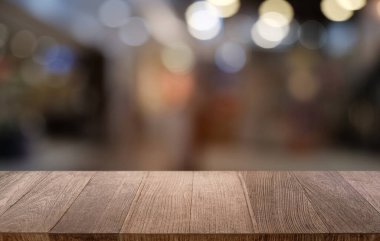 Restoranın soyut bulanık arka planının önündeki boş, siyah ahşap masa. Ürünlerinizi görüntülemek ya da montajlamak için kullanılabilir. 