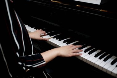 Güzel Asyalı kız piyano çalmayı öğreniyor.