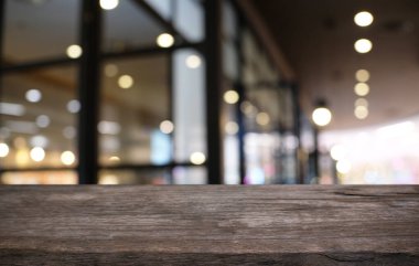 Restoranın soyut bulanık arka planının önündeki boş, siyah ahşap masa. Ürünlerinizi görüntülemek ya da montajlamak için kullanılabilir.