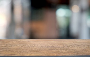 Restoranın soyut bulanık arka planının önündeki boş, siyah ahşap masa. Ürünlerinizi görüntülemek ya da montajlamak için kullanılabilir.