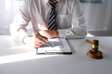 Hukuk danışmanı müvekkiline tokmak ve hukuk hukuku ile imzalanmış bir sözleşme sunar. Adalet ve avukat kavramı