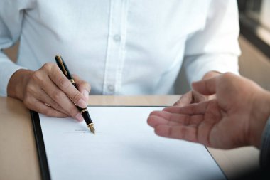 Hukuk danışmanı müvekkiline tokmak ve hukuk hukuku ile imzalanmış bir sözleşme sunar. Adalet ve avukat kavramı