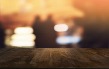 Restoranın soyut bulanık arka planının önündeki boş, siyah ahşap masa. Ürünlerinizi görüntülemek ya da montajlamak için kullanılabilir. 