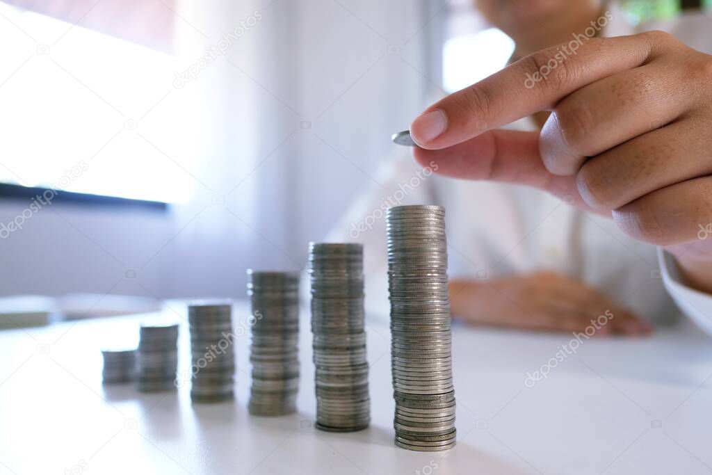 Female hand stack coins  growing business. Saving money