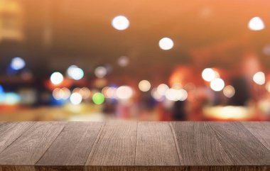 Restoranın soyut bulanık arka planının önündeki boş, siyah ahşap masa. Ürünlerinizi görüntülemek ya da montajlamak için kullanılabilir. 