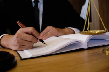 Hukuk danışmanı müvekkiline tokmak ve hukuk hukuku ile imzalanmış bir sözleşme sunar. Adalet ve avukat kavramı