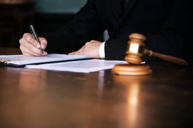 Hukuk danışmanı müvekkiline tokmak ve hukuk hukuku ile imzalanmış bir sözleşme sunar. Adalet ve avukat kavramı