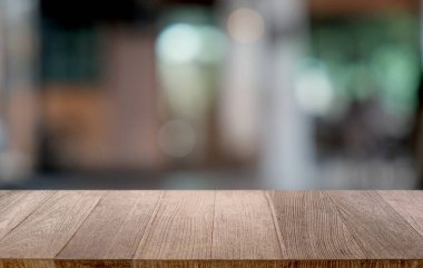 Restoranın soyut bulanık arka planının önündeki boş, siyah ahşap masa. Ürünlerinizi görüntülemek ya da montajlamak için kullanılabilir.