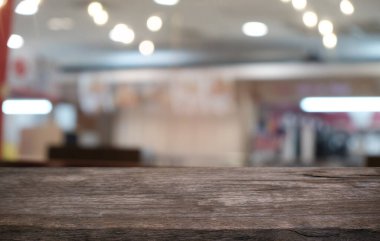 Restoranın soyut bulanık arka planının önündeki boş, siyah ahşap masa. Ürünlerinizi görüntülemek ya da montajlamak için kullanılabilir.